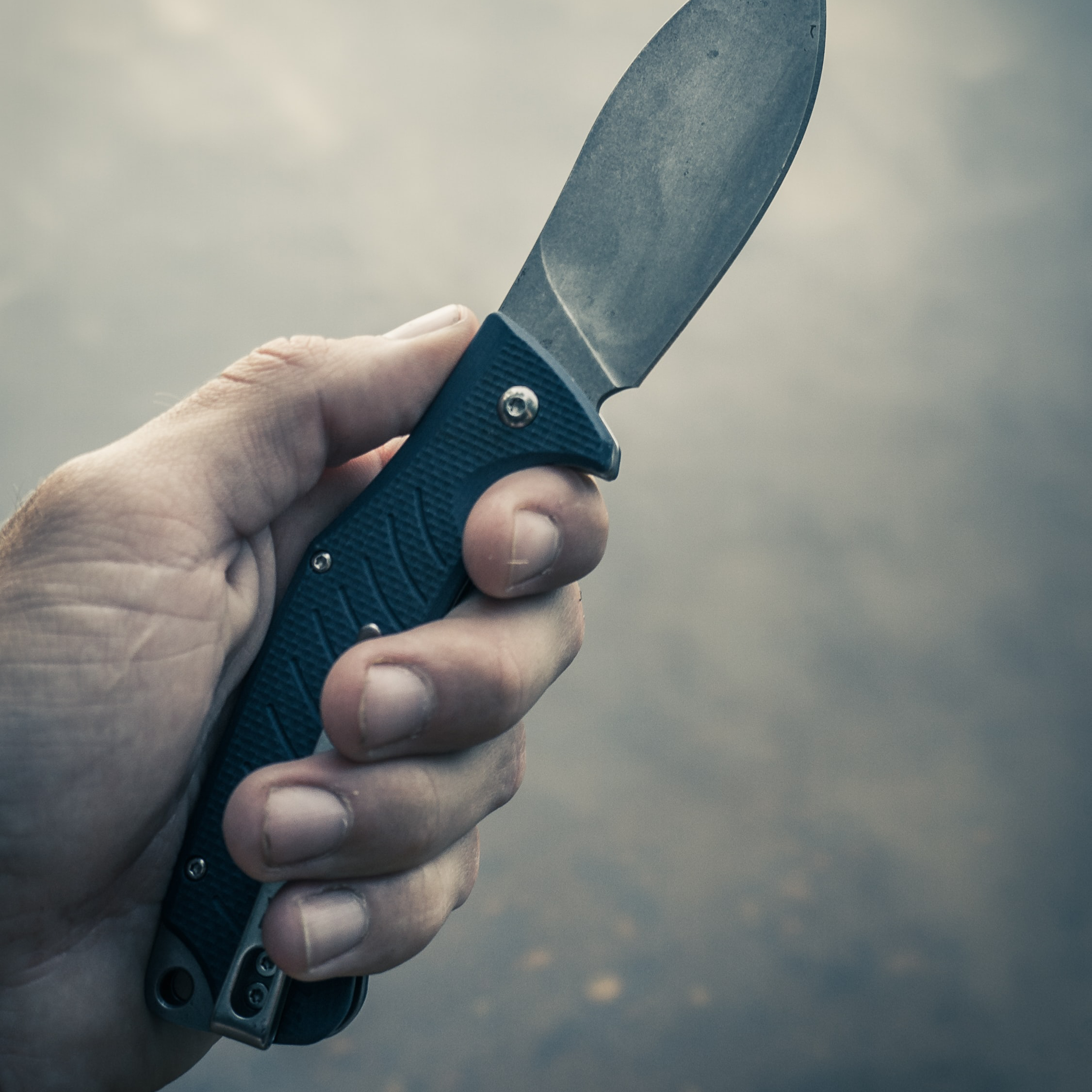 man holding pocket knife with blade extended
